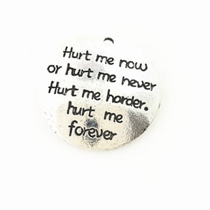 Puede incluir: Encanto de plata con el texto "Hurt me now or hurt me never. Hurt me harder. Hurt me forever."