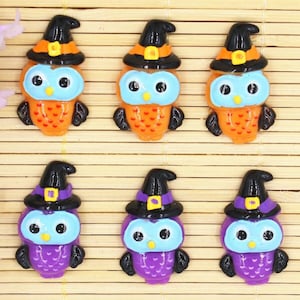 May include: Six Halloween owl charms with black witch hats, orange and purple bodies, and blue eyes.