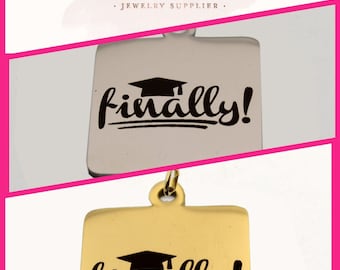 May include: Two gold and silver charm pendants with the text "finally!" and a graduation cap graphic. The charms are on a white background.