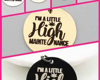 May include: A set of six round metal charms with the text "I'm a little high maintenance" and a marijuana leaf symbol. The charms are in different colors, including silver, gold, black, and rainbow.