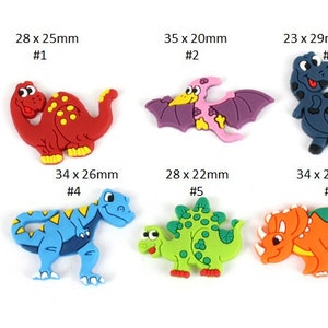 May include: Six colorful dinosaur-shaped plastic buttons, each with a different design and size. The buttons are labeled with their dimensions in millimeters and a number.
