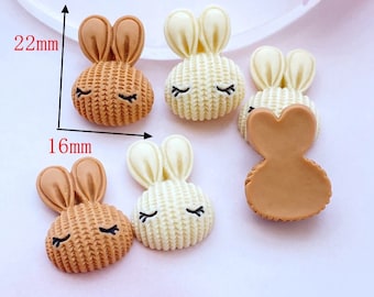 May include: Six small, brown and white bunny-shaped resin embellishments with closed eyes. The bunnies are approximately 1.6 inches (4 cm) wide and 2.2 inches (5.5 cm) tall.