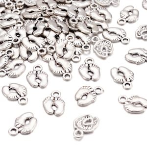May include: A large quantity of silver-toned metal charms shaped like baby footprints. Each charm has a small loop for attaching to jewellery or other crafts.