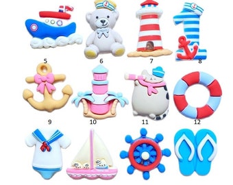 May include: Twelve colorful nautical themed cake toppers, including a boat, a teddy bear, a lighthouse, a number one, an anchor, a cat, a life preserver, a sailor outfit, a sailboat, a ship's wheel, and flip flops.