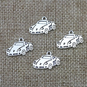 May include: Four silver charm pendants shaped like cars. Each charm has a detailed outline of a car with wheels and a windshield.