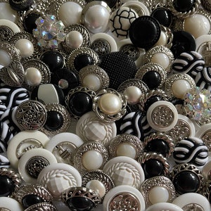 May include: A collection of black and white buttons with various designs and textures. The buttons are made of different materials, including plastic, metal, and fabric. Some buttons have a shiny finish, while others have a matte finish.