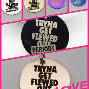 May include: A set of six round metal charms with the phrase "Tryna Get Flewed Out PeriodT" engraved in black. The charms are in various colors, including silver, gold, black, blue, and rainbow.