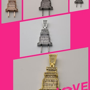 May include: A collection of pendant necklaces in the shape of a plug. The pendants are in gold, silver, and gunmetal colors, all encrusted with small, sparkling stones. The image includes the text "LOVE STORY".