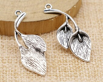 May include: Two silver-toned metal leaf charms with a stem and a loop for attaching to jewelry or other crafts.