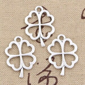 May include: Three silver-toned four-leaf clover charms with a loop at the top for attaching to jewelry or other crafts.