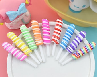 May include: A set of ten colourful swirl candy lollipops on white sticks. The lollipops are arranged in a semi-circle on a white plate. The lollipops are in the following colours: pink, yellow, green, orange, red, blue, purple, and rainbow.