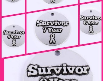 May include: A set of nine silver-toned round charms with the word "Survivor" and a number from 2 to 9, each with a pink ribbon symbol. The charms are for making jewelry or crafts.