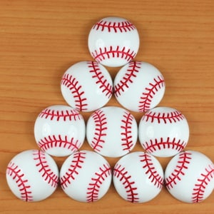 Könnte beinhalten: Eine Gruppe von neun weißen Baseballs mit roten Nähten, die in Pyramidenform auf einer Holzoberfläche angeordnet sind.