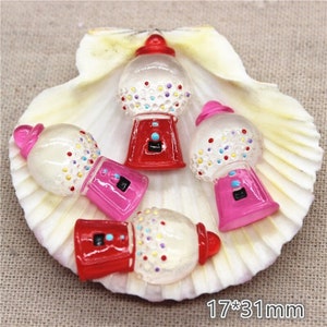 May include: Four colorful gumball machines with a clear plastic body and a red, pink, or white base. The gumball machines are decorated with colorful dots and are approximately 1.25 inches tall.