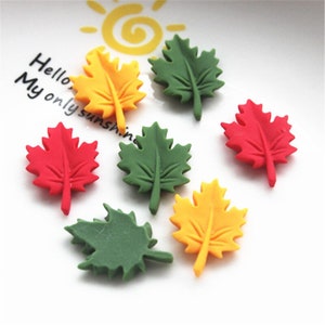 May include: Assortment of six colorful maple leaf shaped embellishments. The leaves are made of a soft, pliable material and are available in red, green, and yellow.