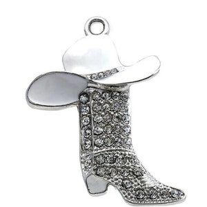 May include: Silver charm with a white cowboy hat and boot covered in rhinestones.
