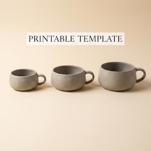 May include: Three gray ceramic mugs of varying sizes with rounded bodies and small handles. The mugs are arranged in a row against a neutral background. The text "PRINTABLE TEMPLATE" is displayed above the mugs.