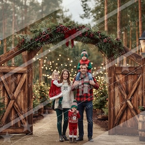 May include: A family of five poses in front of a wooden archway decorated with greenery and red berries. The family is dressed in festive winter attire, including sweaters and hats. The scene is set outdoors with Christmas trees and string lights.