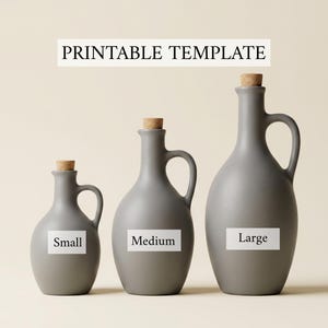 以下が含まれることがあります： コルク栓とサイドハンドルが付いたマットグレーのセラミックボトル3本が、サイズの小さい順に並んでいます。各ボトルには、Small、Medium、Largeと書かれた黒い文字の白い長方形のラベルが付いています。上部のテキストにはPRINTABLE TEMPLATEと書かれています。