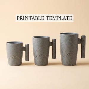 May include: Three gray ceramic mugs of varying sizes with a mountain design and a unique handle. The mugs have a speckled texture and the text "PRINTABLE TEMPLATE" is displayed above them.