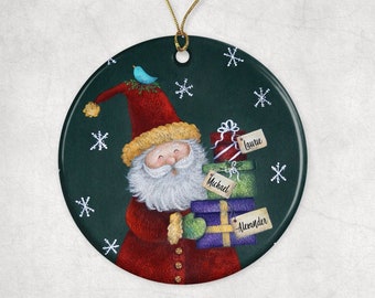 May include: A round, green Christmas ornament with a white snowflake pattern. Santa Claus is depicted carrying a stack of presents with the names "Laurie", "Michael", and "Alexander" written on the gift tags.