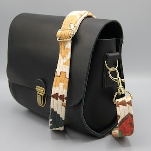 Sac à main en cuir de couleur noir et sangle réglable en tissus