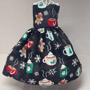 May include: A black dress with a festive Christmas print featuring mugs of hot chocolate, gingerbread people, and snowflakes.