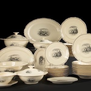 Könnte beinhalten: Eine Sammlung cremefarbener Porzellan-Essgeschirr mit einem schwarz-weißen pastoralen Szenen-Design. Das Set umfasst Teller, Schalen, Servierschalen und abgedeckte Terrinen. Jedes Stück hat einen gewellten Rand und eine dekorative Bordüre.