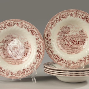 Può includere: Un set di ciotole da zuppa in ceramica color crema con un motivo a trasferimento rosso scuro. Il bordo presenta un'intricata decorazione di foglie di quercia e ghiande, mentre il centro raffigura una scena dettagliata di figure a cavallo in un paesaggio rurale.