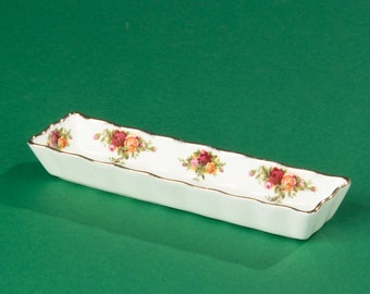 Può includere: Un piatto da portata rettangolare bianco con un bordo dorato e un motivo floreale con rose rosse, gialle e verdi.