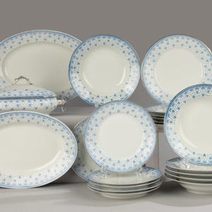 Op de afbeelding: Een set wit porselein serviesgoed met een blauw bloemenpatroon. De set bevat een verscheidenheid aan borden, kommen en een serveerschaal.