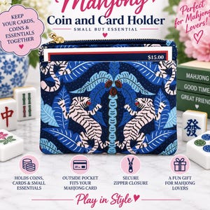 May include: A rectangular coin and card holder featuring a dark blue fabric with a repeating pattern of white tigers and blue palm leaves. The pouch has a gold-toned zipper closure at the top and an exterior pocket containing a card with $15.00 printed.