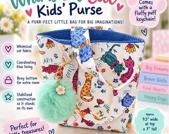 May include: A white tote purse featuring a colorful cat and floral pattern with a blue interior lining. The bag includes a mint green fluffy pom-pom keychain with a white flower charm. Text on the bag indicates it is 9.5 inches wide and 7 inches tall.