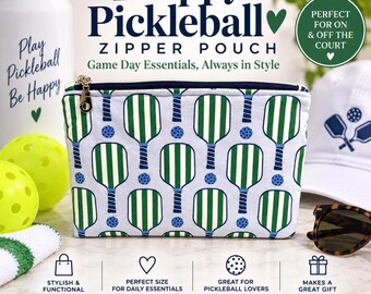 May include: A rectangular zipper pouch featuring a repeating pattern of green and white striped pickleball paddles and small blue pickleballs on a light blue background, with a dark blue zipper closure and a gold-toned metal zipper pull.