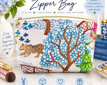 May include: A white fabric zipper bag featuring a colorful print of a leopard, a large blue tree with circular leaves, a green pagoda, and brown bridge structures. The bag has a gold-toned metal zipper closure and a boxy bottom design for storage.
