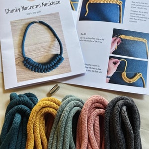 May include: A kit for making a chunky macrame necklace. The kit includes four spools of cord in teal, mustard yellow, dusty rose, and charcoal grey. The instructions are printed on two sheets of paper and show a finished necklace in teal.