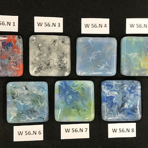 May include: Eight square glass tiles with different abstract patterns in shades of blue, gray, white, red, and yellow. The tiles are labeled with the text "W 56.N 1" through "W 56.N 8".