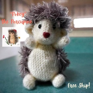 May include: A crocheted plush toy hedgehog with gray fur and a white body. The toy is sitting on a teal surface. The text ""Pokey" The Porcupine" is visible in the image.