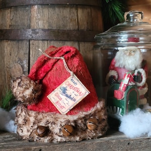 Chapeau de père Noël en peluche grunge nostalgique de Noël rustique Primitive Farmhouse avec grelots rouillés et étiquette ancienne perforée à la main.