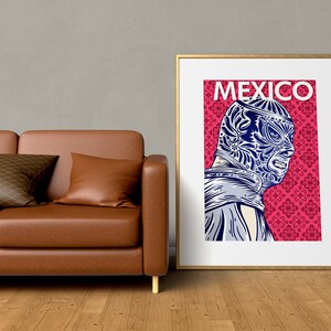 May include: A framed poster with a pink background and a blue and white illustration of a masked wrestler. The poster has the word "MEXICO" printed in white at the top.