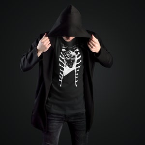 May include: A black hooded jacket with a black t-shirt underneath. The t-shirt features a white graphic of a character from Star Wars.