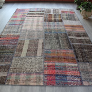 Pode incluir: Um tapete de patchwork com uma variedade de cores e padrões, incluindo vermelho, azul, verde e marrom. O tapete é feito de diferentes tecidos e texturas, e tem um visual envelhecido.