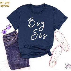 a t - shirt that says big sis next to a pair of jeans