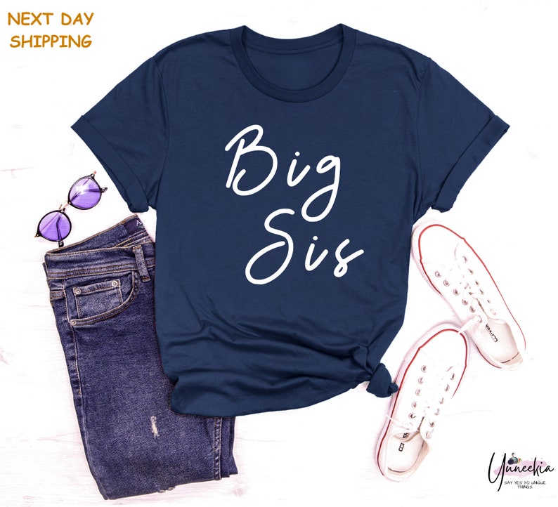 a t - shirt that says big sis next to a pair of jeans
