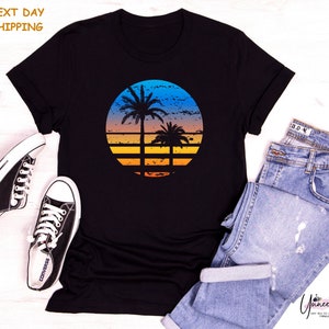 a t - shirt with a sunset and a palm tree on it