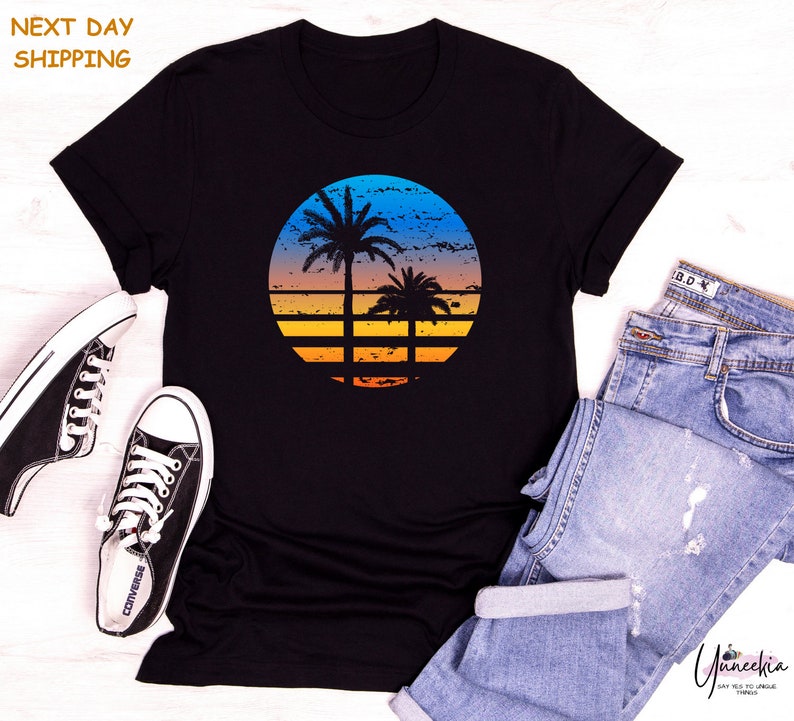 a t - shirt with a sunset and a palm tree on it