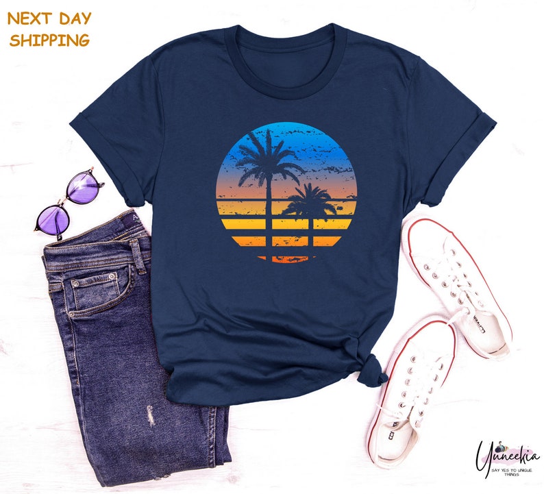 a t - shirt with a sunset and palm trees on it