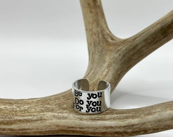 Puede incluir: Anillo de plata con las palabras "Be you, Do you, For you" grabadas.