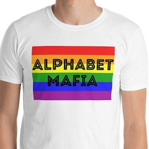Puede incluir: Camiseta blanca con un diseño de bandera arcoíris y el texto "Alphabet Mafia" en negro.