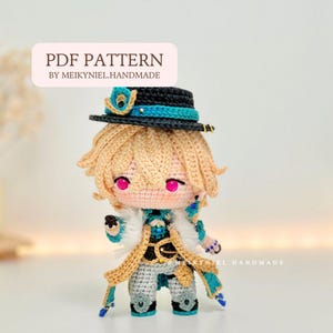 May include: Crochet amigurumi doll pattern PDF. The doll is wearing a black and teal hat, a teal and white jacket, and a brown and white waistcoat. The doll has blonde hair and pink eyes.